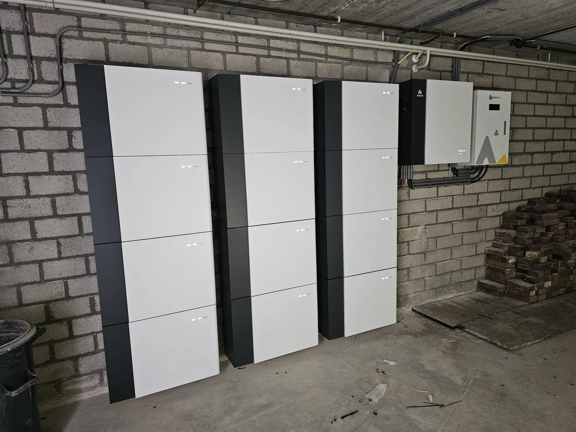 Drie AlphaESS-thuisbatterijen tegen de muur in een garage